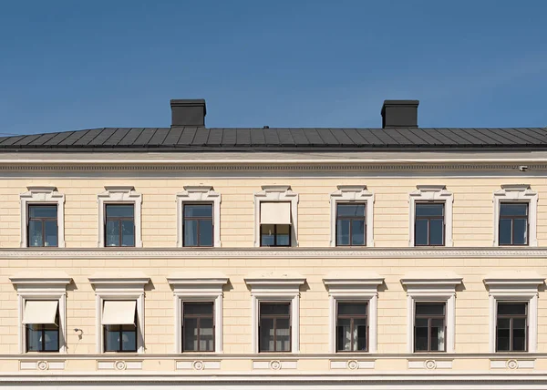 Fassade des Stadtgebäudes, Fenster und Dach gegen den blauen Himmel — Stockfoto