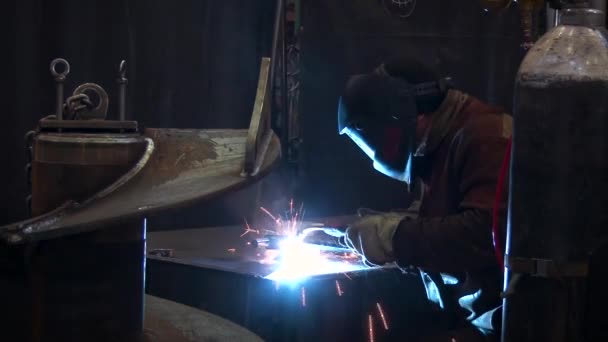 Close up view of a man in protective clothing in welding process of the iron detail. — Stock Video