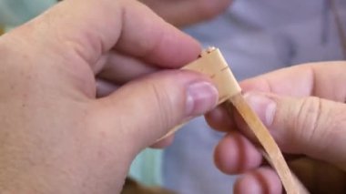 Erkek elleri ahşap şeritler sallarken yakın plan görüntüsü.