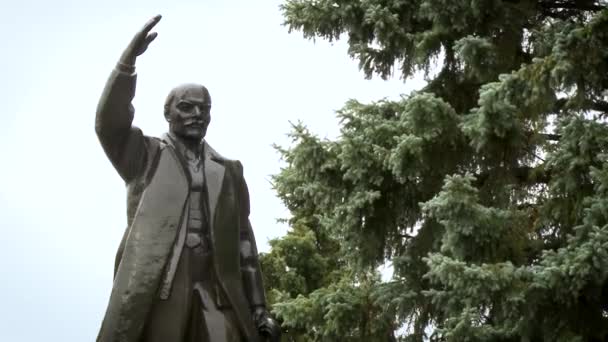 Vue rapprochée du monument de Lénine contre le ciel parmi les arbres. — Video