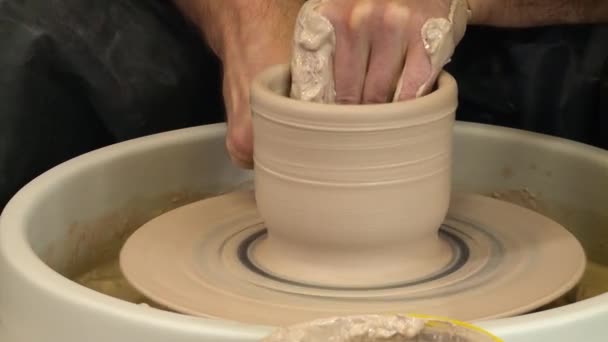 Blisko widok męskich rąk kształtujących glinę na kole ceramicznym. — Wideo stockowe