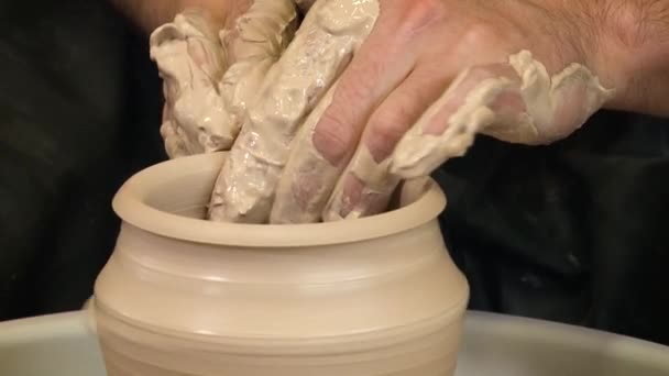 Close view of male hands working with clay on a pottery wheel — Stock video