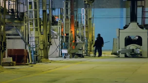 Two workers with the help of brooms clear the dirt and dust equipment in production — Stock Video