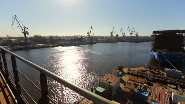 Vista panorâmica da ponte de navios para o navio no porto, um monte de armazéns e contentores para o transporte de mercadorias — Vídeo de Stock