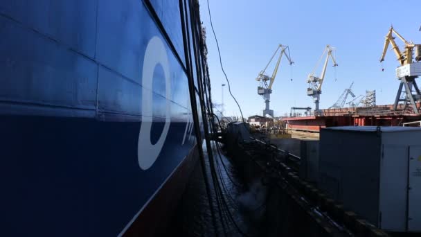 Панорамный вид корабля синего цвета, стоящего в порту. Торговое судно пришвартовано.. — стоковое видео