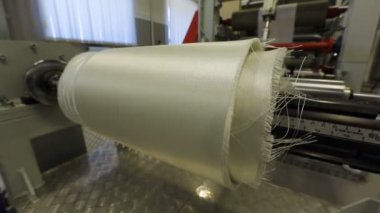 Üretimde kullanılan sentetik kumaşı sarmak için bir cihaz.