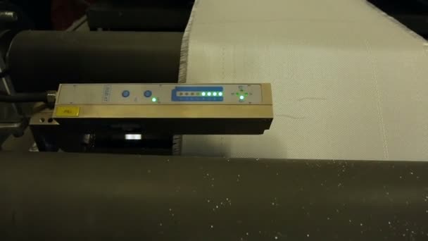 Desplazamiento de tela sintética en la cinta de producción con la ayuda de ejes. Producción automatizada. — Vídeos de Stock