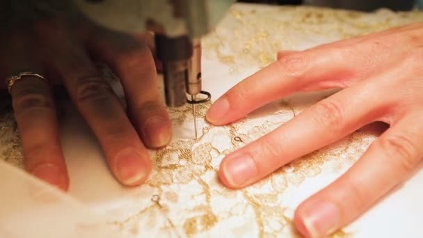 Industrie de la couture. Femme coud des motifs avec des fils d'or sur une machine à coudre. Gros plan — Video