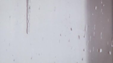 Dondurucu bir damla pencereden aşağı akıyor. Yakın çekim.