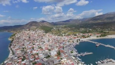 Şehrin kıyı manzarası. Deniz ve evlerle çevrili dağların havadan görünüşü.