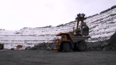 Taş ocağında kazı yapan kamyonların yön değiştirme perspektifi. Madencilik işlemleri.
