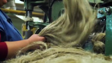 Bir kadının yakın plan çekimi dokuma tezgahında yün hazırlar..