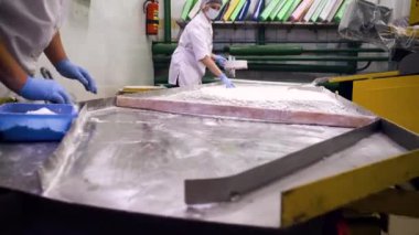 Üniformalı bir kadının kemik taşıyıcıdaki kızılcıklara şeker serptiği yakın bir görüntü..