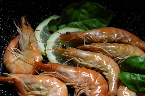 Shrimp cooked with lemon on a black background