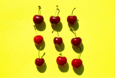 sarı bir arka plan üzerinde kırmızı tatlı kiraz