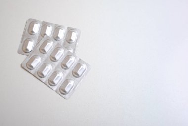 Gümüş alüminyum Vakumlu Ambalaj kopya alanı metin için beyaz zemin üzerine izole tıpta hap kapsül. İlaç üretim kavramı ambalaj. Vakumlu Ambalaj üzerinde beyaz izole hapları ile. Beyaz arka plan üzerinde izole boş blister paketleri.
