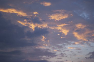 Kararan bir gökyüzü, arka plan, batan güneşin ışığında akşam bulutlar.