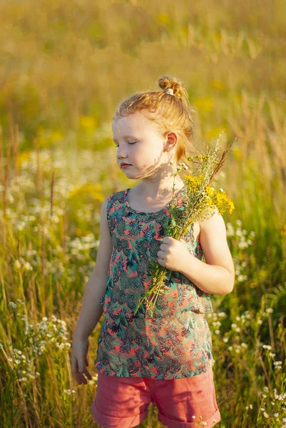 Giovane ragazza felice con un fiore in mano contro il cielo blu — Foto Stock
