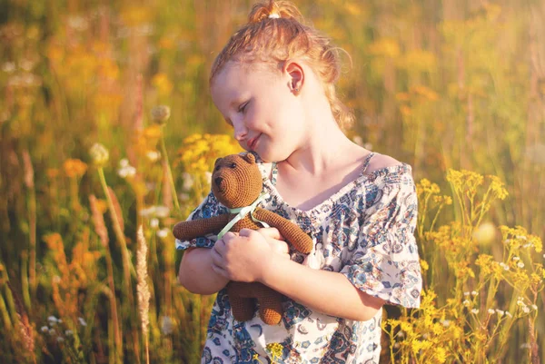 Felice ragazza con un fiore in mano contro l'erba verde — Foto Stock