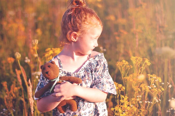 Felice ragazza con un fiore in mano contro l'erba verde — Foto Stock