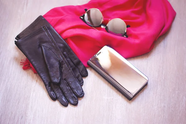 Espelho caso telefone e espelho óculos de sol e lenço rosa na mesa de madeira — Fotografia de Stock