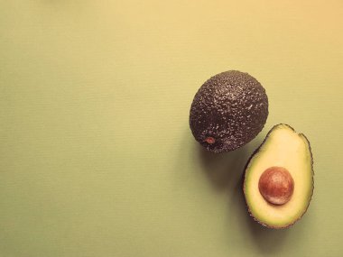 Hass avokado yeşil bir arka plan üzerinde. Vegan hayat. Sağlıklı yiyecekler. Gıda yeşil.