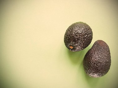 Hass avokado yeşil bir arka plan üzerinde. Vegan hayat. Sağlıklı yiyecekler. Gıda yeşil.