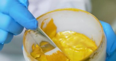 Güzellik uzmanı tıbbi klinikte güzel kızın yüzündeki altın kozmetik maske uygulamak