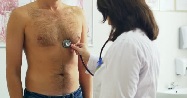 Klinice lékař zkoumání člověka tím stetoskopem — Stock video