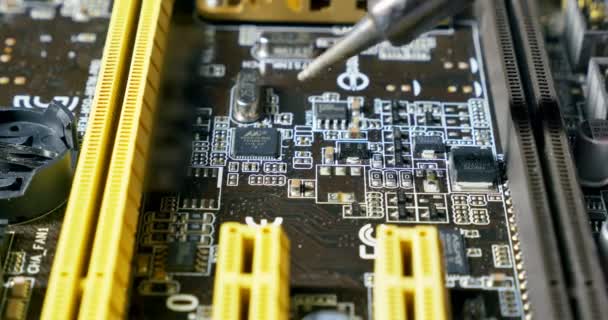 Solderen een printplaat met een soldeerbout. Close-up shot van reparatie op computers en elektronica service — Stockvideo