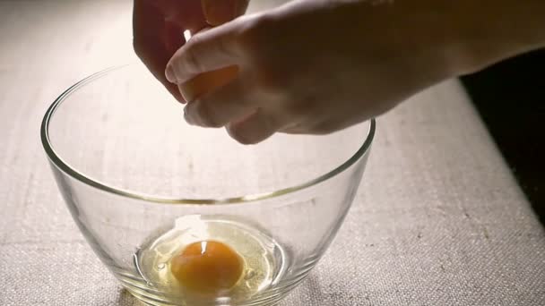 Romper los huevos en un tazón de vidrio. Preparación de ingredientes para hornear. Cocinando, de cerca. Movimiento lento — Vídeo de stock