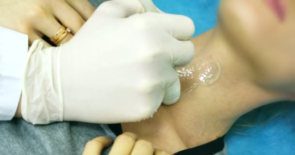 Doctor making a ultrasound diagnostic of neck. Looking to thin neck of young women at ultrasound device screen on the hospital — Stock Footage Doctor making a ultrasound diagnostic of neck. Looking to thin neck of young women at ultrasound device screen on the hospital Video Clip