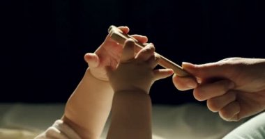 Yatakta ahşap oyuncak ile oynayan sevimli meraklı bebek yakın çekim. Küçük bebek karanlık odada gece ahşap oyuncaklar ile oynuyor