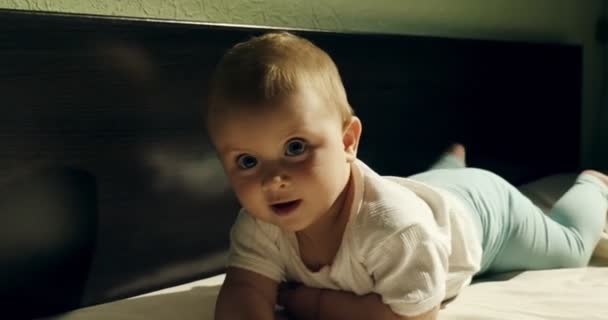 Close-up de adorável bebê curioso brincando com brinquedo de madeira na cama. Pequeno bebê brincando com brinquedos de madeira à noite no quarto escuro — Vídeo de Stock