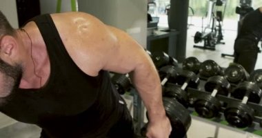Genç Güçlü adam eğimli dumbbell basın, spor salonu egzersiz, yoğun egzersiz, ağırlık kaldırma, vücut geliştirme performans