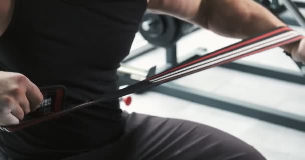 젊은 근육 질의 남자는 훈련 하기 전에 체육관에서 붕대와 팔을 붕대. 슬로우 모션 — 비디오