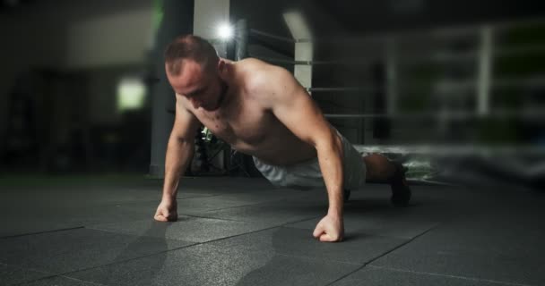 Muscular Shirtless Man does Push-ups in a Gym. Intense workout exercise. Slow motion — Stock Video