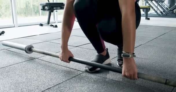 Forte músculo de treinamento de mulher bonita com barra no clube de esporte. Atleta feminino fazendo exercício na academia moderna — Vídeo de Stock