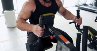 Spor kulübünde spor simülatörü güçlü adam eğitim kas. Atlet erkek modern spor salonunda fitness makinesi üzerinde egzersiz yapıyor