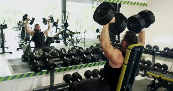 Pemuda kuat melakukan cenderung dumbbell tekan, latihan gym, latihan intens, angkat berat badan, binaraga — Stok Video