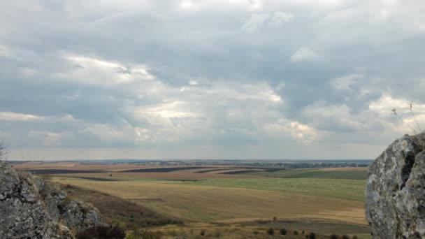 Felhők mozognak a kőzetképződés és a mező felett — Stock videók