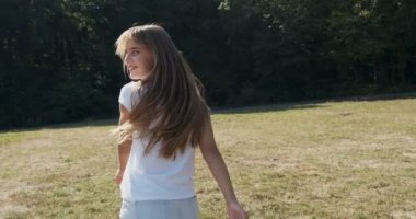 Beni takip et, mutlu gülümseyen genç kız koşuyor ve senden onu takip etmeni istiyor. Genç çekici kadın güneşe koşup gülümsüyor.