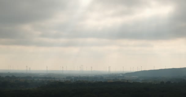 Silhuetter av vindkraftverk under rörliga solstrålar — Stockvideo