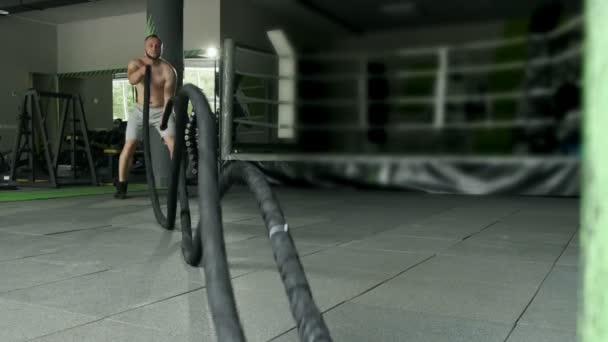 Фитнес-атлет использует боевые веревки в тренировках. Интенсивные тренировки. Сверхмедленное движение — стоковое видео