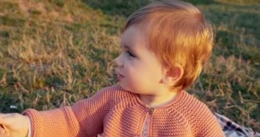 Küçük kız parkta oynuyor. Yeşil çimlerde, temiz havada.