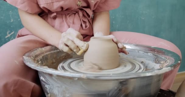 Žena hrnčíř sedí a dělá šálek na hrnčířském kole. Žena vyrábějící keramické předměty. Pottery working, handmade and creative skills — Stock video