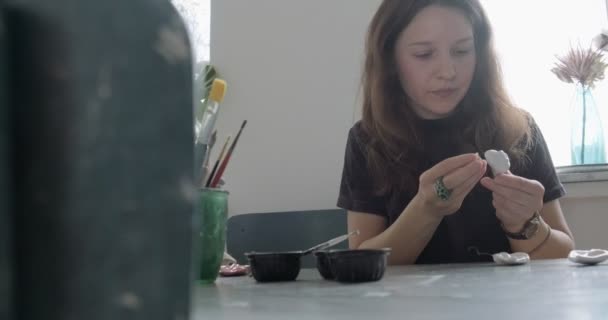 Donna rendendo bambola parte in ceramica. Femmina seduta e creando orecchio per bambola a casa a tavola. Parti di bambole di ceramica, abilità fatte a mano e creative — Video Stock