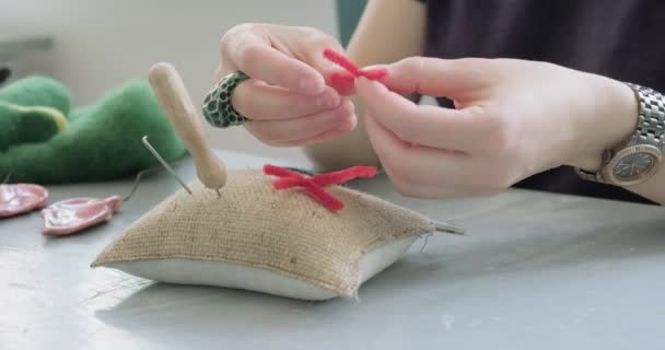 Mulher fazendo brinquedo de boneca de arte de lã na mesa de perto. Feminino sentado e criando boneca de carvalho em casa. Agulha de feltro Handmade e habilidades criativas — Vídeo de Stock