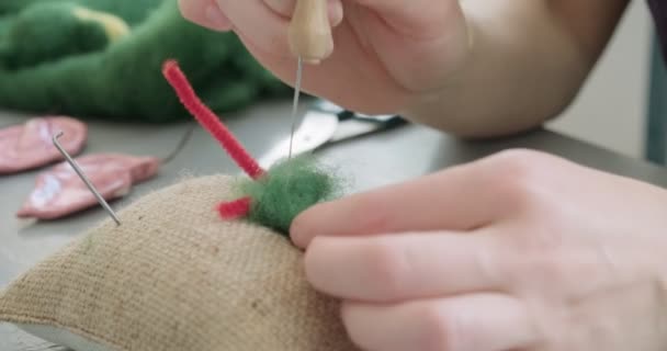 Vrouw maken wol kunst pop speelgoed aan tafel close-up. Vrouwelijke zittende en het creëren van ooak pop thuis. Naaldvilt Handgemaakte en creatieve vaardigheden — Stockvideo