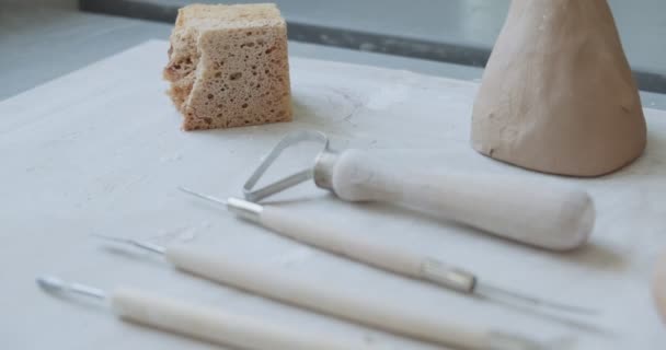 Primer plano de las herramientas de cerámica en el taller. Mujer haciendo artículo de cerámica. Trabajo de cerámica, habilidades hechas a mano y creativas — Vídeo de stock